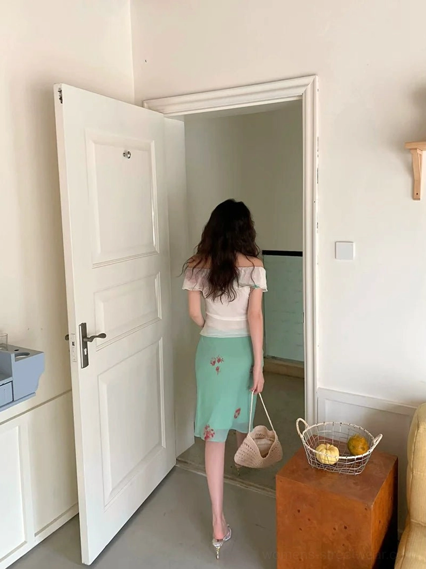 Back view of white ruffled off-shoulder floral bow blouse showing the fitted cropped silhouette styled with a printed midi skirt