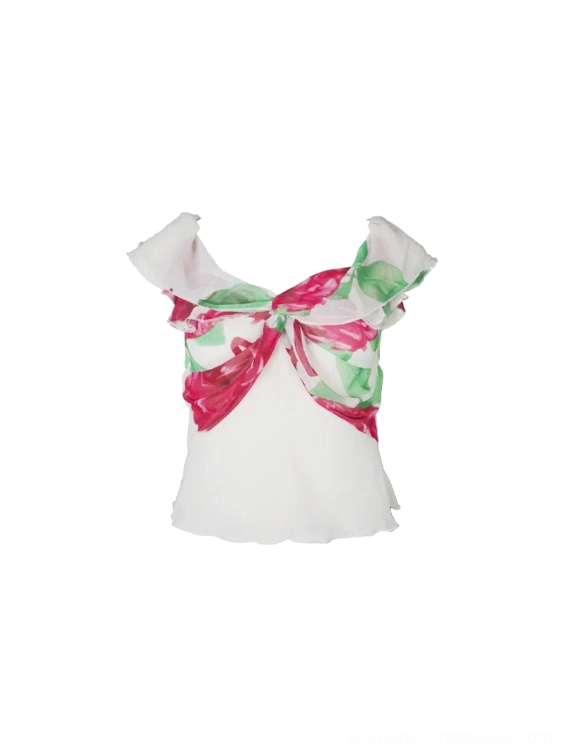 White sheer off-shoulder peplum blouse flat lay with ruffled neckline and oversized red green floral bow front detail
