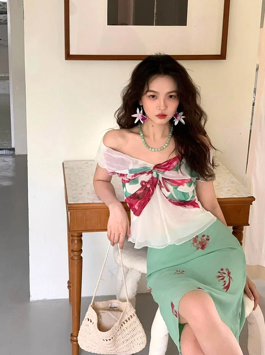 Front view of romantic white floral bow off-shoulder peplum blouse styled with a mint floral midi skirt in a vintage-inspired interior