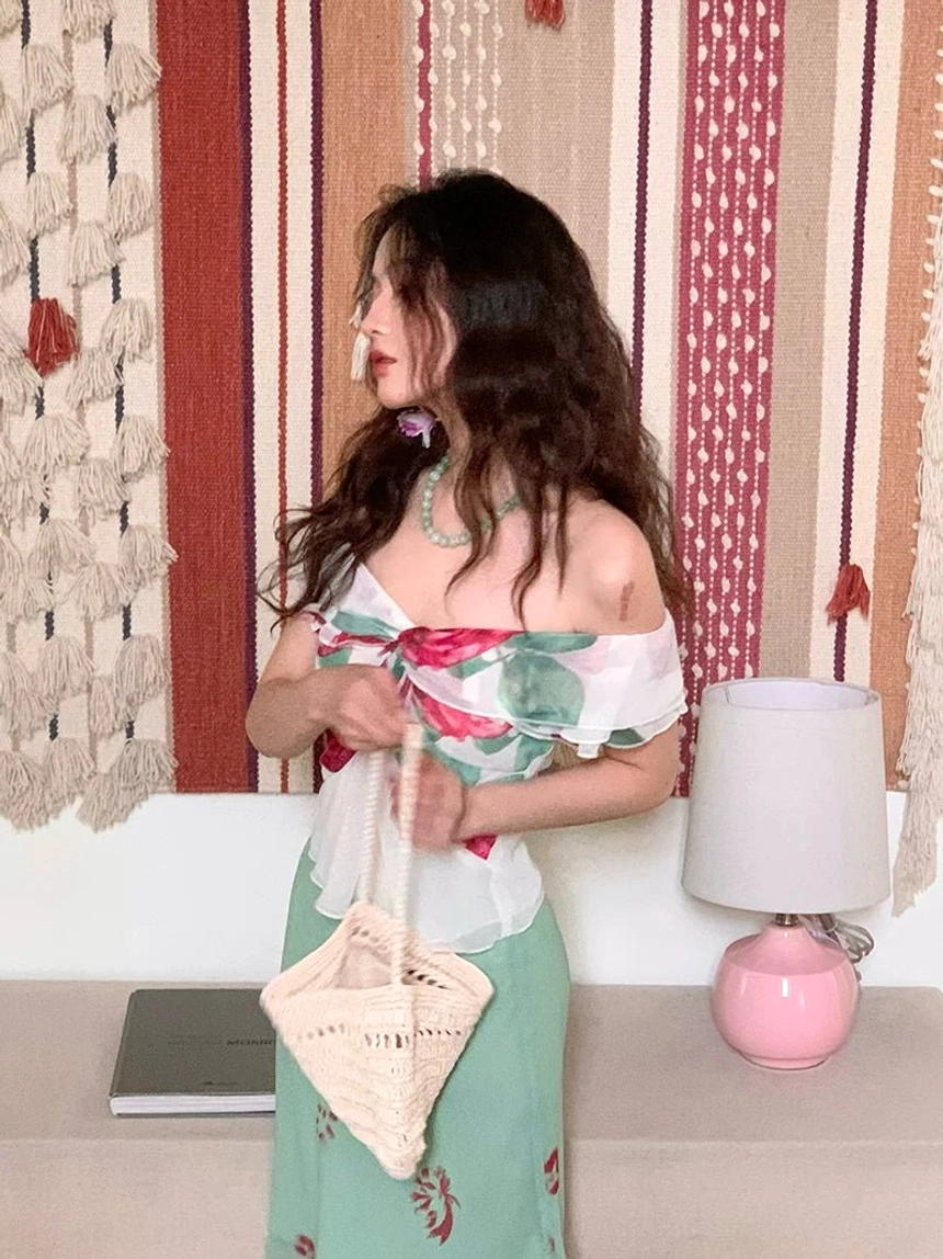 Side view of white floral bow off-shoulder blouse with ruffled neckline and waist-defining peplum hem in romantic streetwear styling