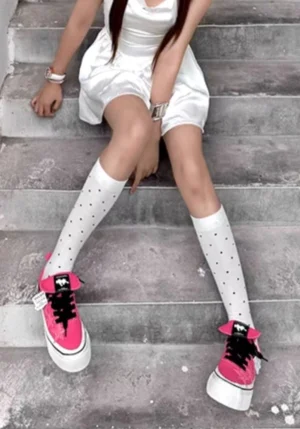 Rose pink star panel canvas sneakers worn with a white mini dress and polka dot knee-high socks in a casual streetwear outfit