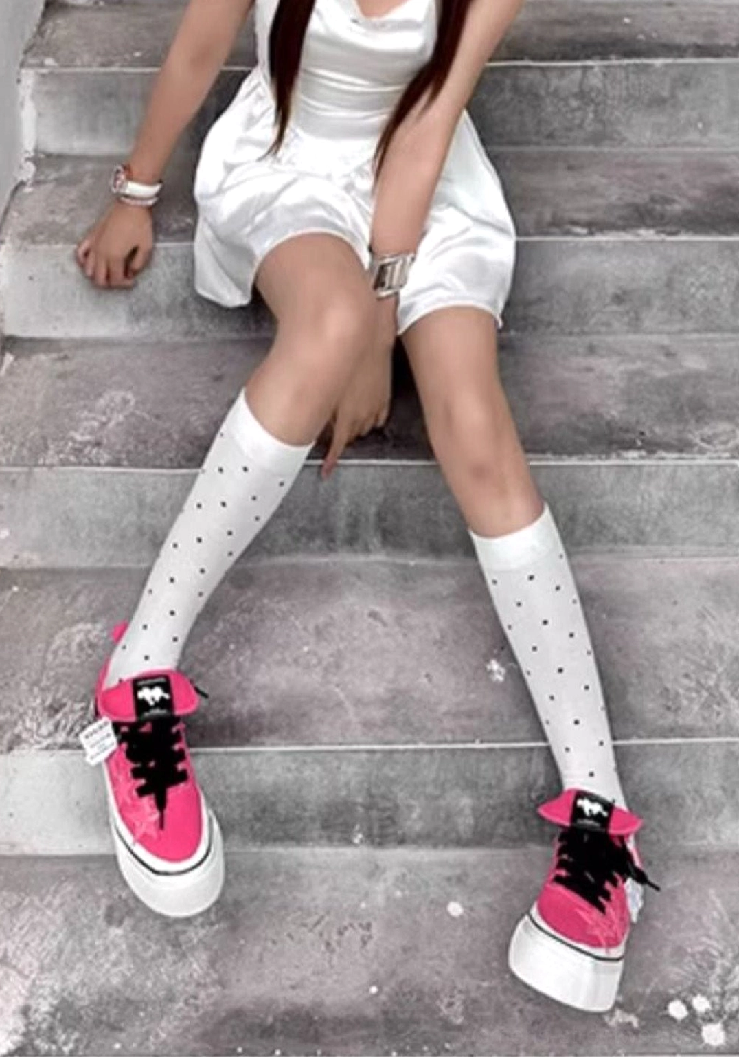 Rose pink star panel canvas sneakers worn with a white mini dress and polka dot knee-high socks in a casual streetwear outfit