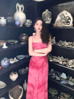 Rose Red tie-dye spaghetti strap maxi dress with square neckline, wrap waist sash, fitted bodice, and floor-length draped skirt styled in a vintage indoor setting