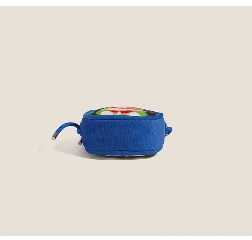 Rear side view of lightweight royal blue cartoon mini crossbody bag showing bag depth and zipper pull