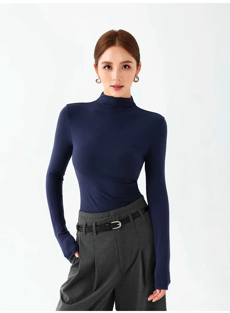 Royal blue slim fit mock neck long sleeve top styled with a belt and high waisted gray trousers