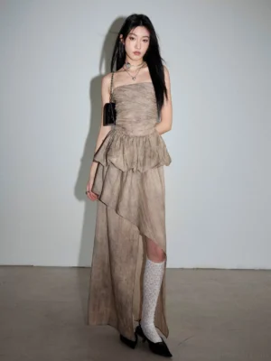Front full-body view of a dusty khaki ruched two-piece streetwear set with fitted strapless top, ruffled peplum waist, and asymmetric long skirt