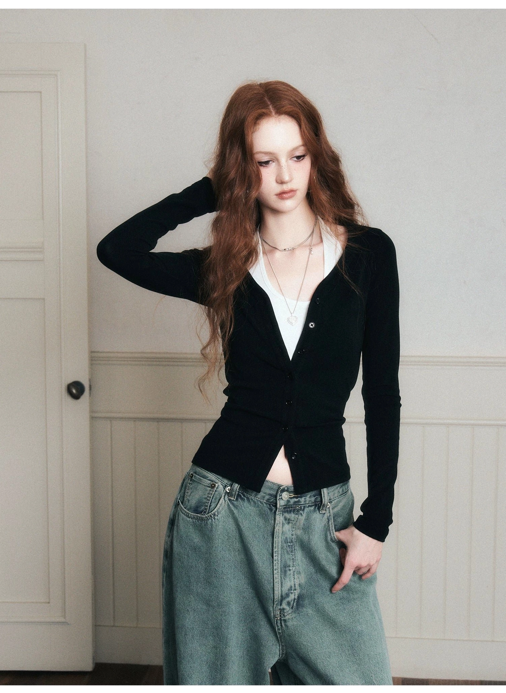 Black layered knit cardigan and white halter top set with a fitted waist shown from a low angle