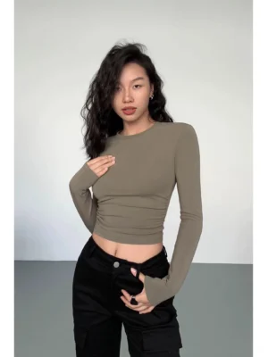 Taupe ruched second-skin cropped long sleeve top with thumbhole sleeves styled with black cargo pants