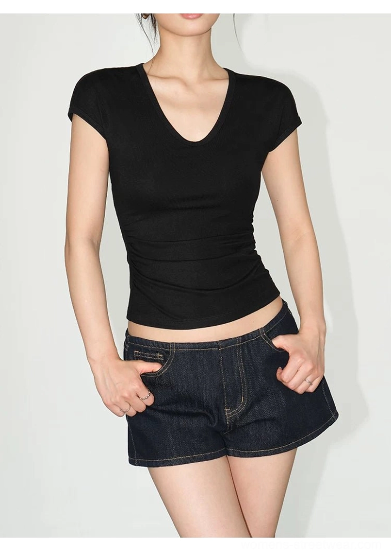 Black ruched V-neck sculpting knit baby tee for women paired with dark denim shorts in studio