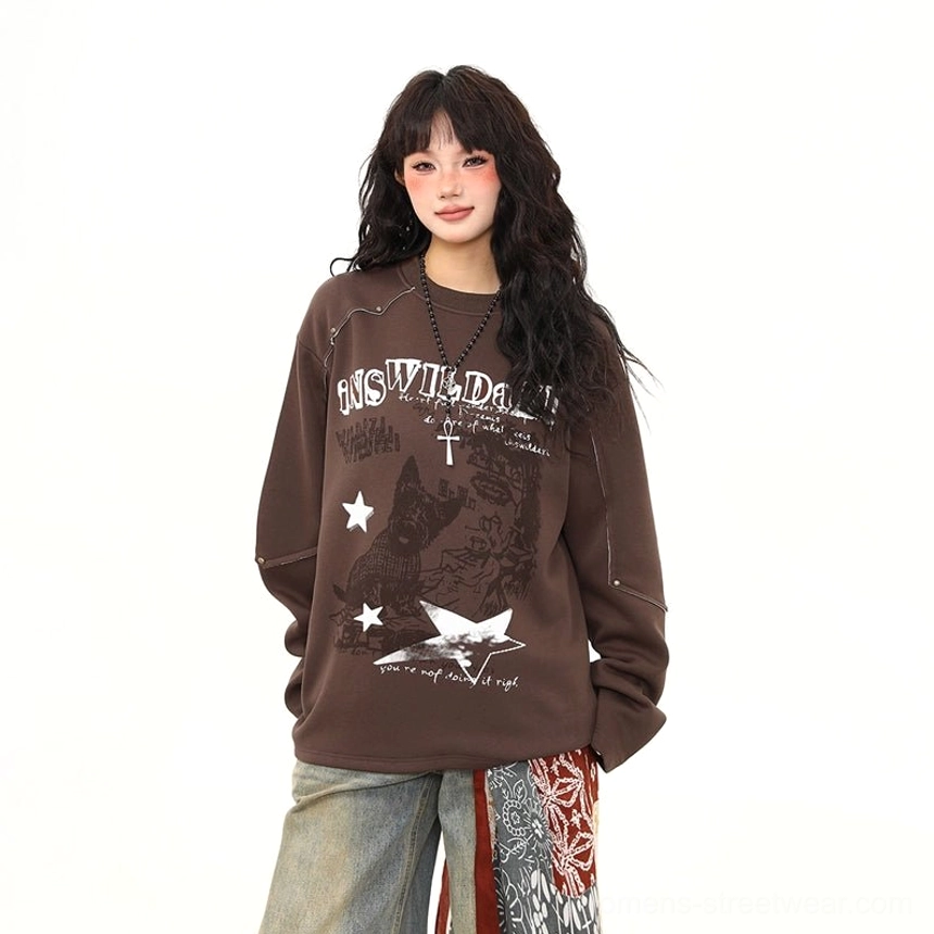 Front medium full-body view of rust rebel brown oversized graphic sweatshirt with distressed punk print and wide-leg jeans