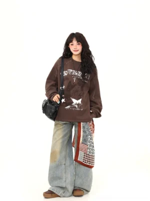 Three-quarter front view of brown vintage punk graphic sweatshirt with relaxed oversized fit and black crossbody bag styling