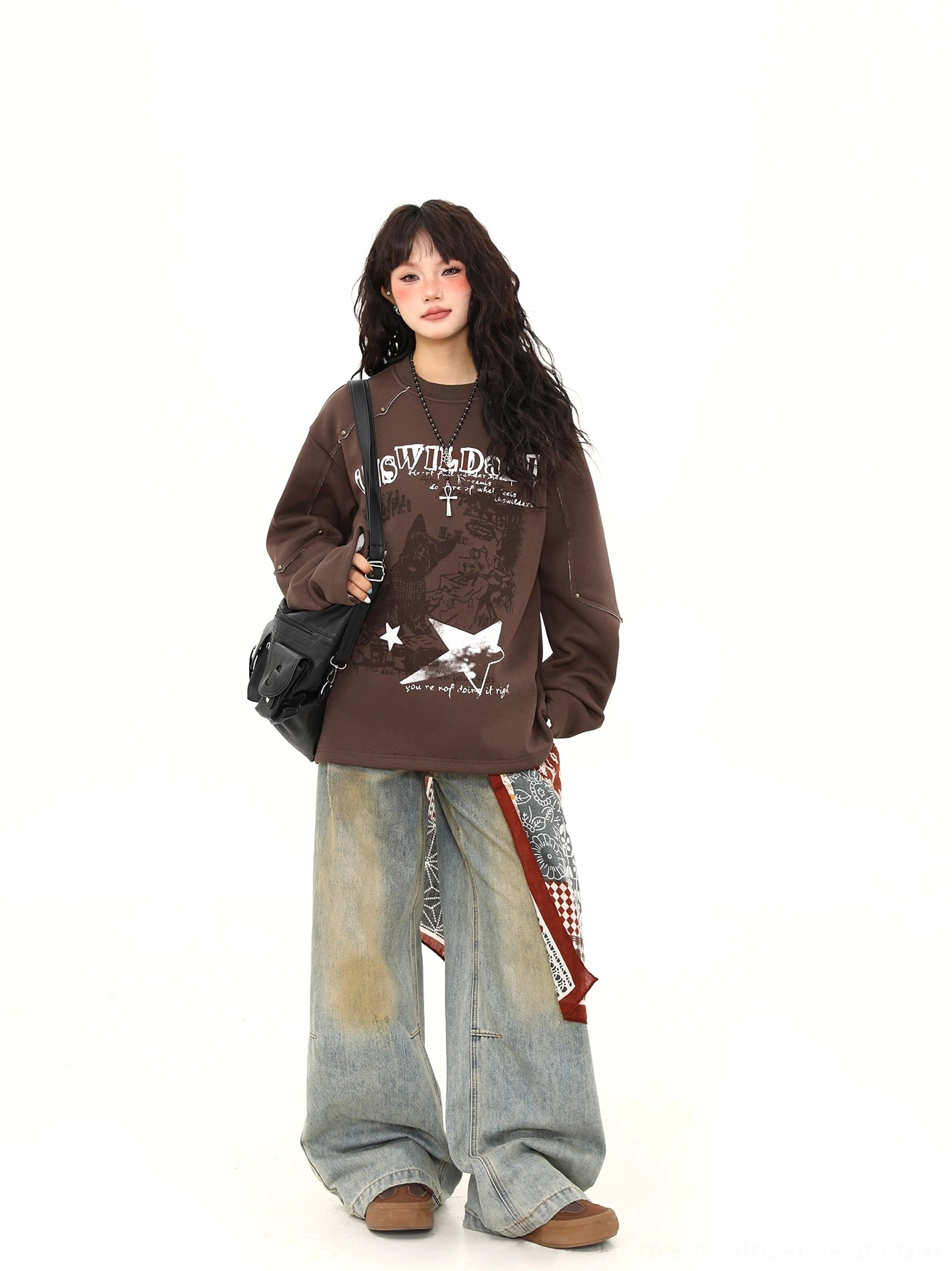 Side-front view of oversized brown punk graphic sweatshirt showing contrast shoulder seam detail and relaxed sleeve construction