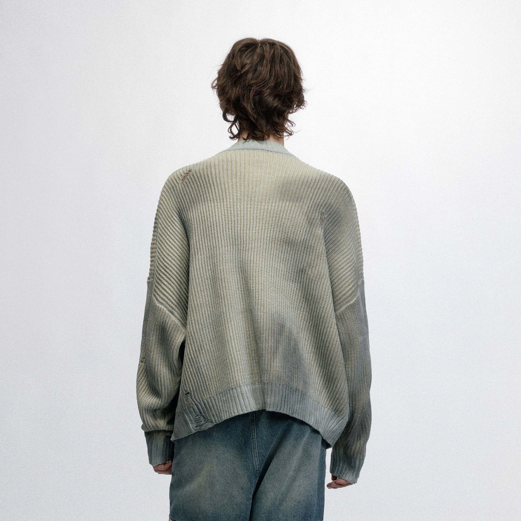 Back view of a male model wearing a sage gray ribbed logo sweater with a relaxed oversized Korean streetwear fit