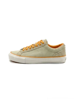 Sage green colorblock suede low-top skate shoes with bright orange laces, orange piping, padded collar and white rubber sole side profile