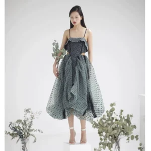 Front view of sage green polka dot strapless midi dress with removable black straps, ruffled bodice, waist cutout, asymmetrical tulle skirt, and modern Korean fashion styling