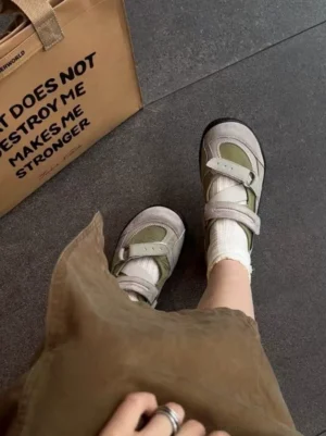 Sage green Velcro trail sneakers worn with white crew socks and a brown midi skirt in a casual streetwear outfit