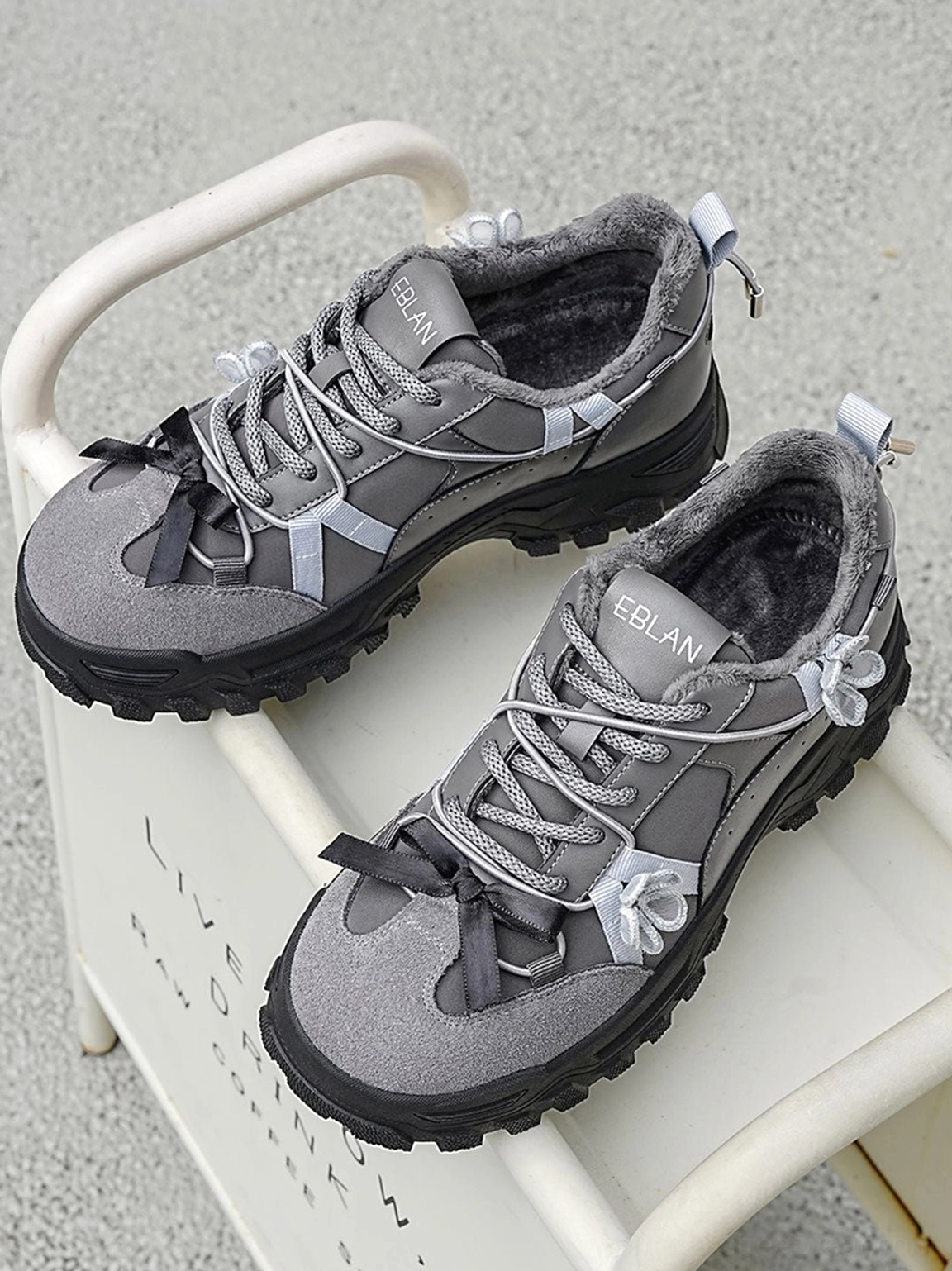 Sakura plush chunky trail sneakers product image showing oversized low top silhouette soft lining decorative flower laces and gorpcore inspired lug sole