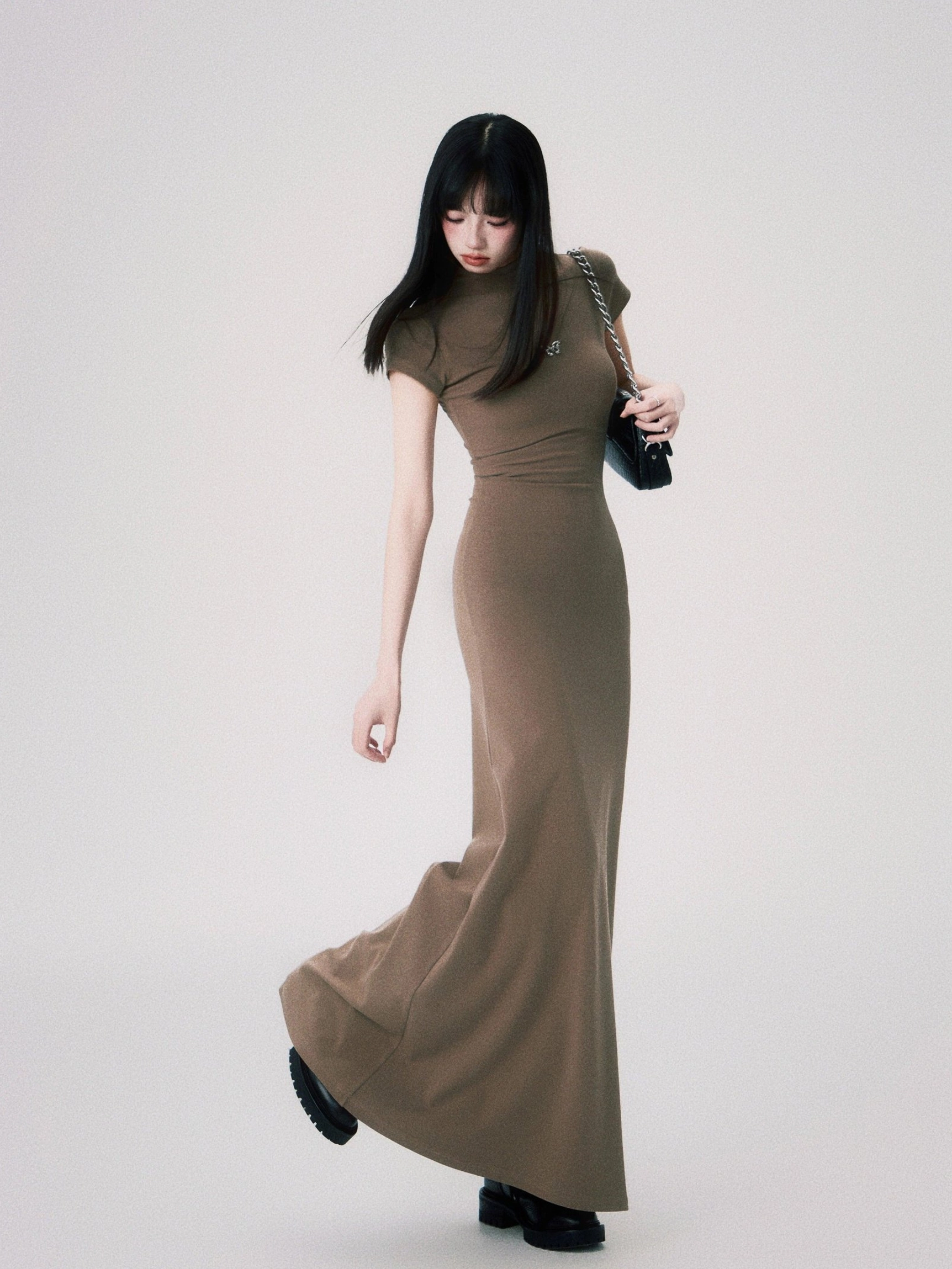 Sand butterfly emblem maxi dress shown in motion with a flowing fishtail hem and tailored slim fit