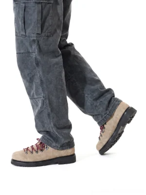 Sand suede hiking-lace derby shoes worn with washed dark grey cargo pants from low rear walking angle