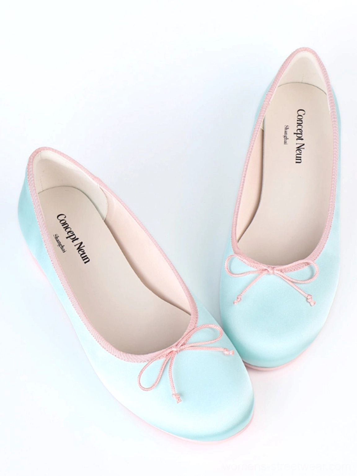 Close-up front view of light blue satin bow ballet pumps showing the low-cut opening and contrast trim