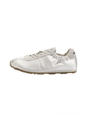 White satin low-profile lace-up sneakers with rounded toe, paneled upper, and gum rubber outsole in a studio side view