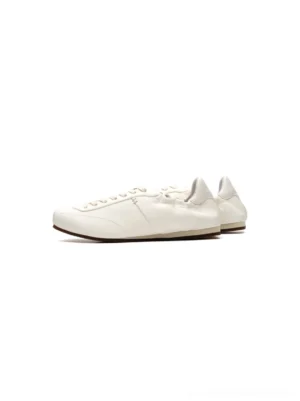 White women's low-profile retro trainers with a slim rounded silhouette and minimalist ribbon lace-up streetwear design