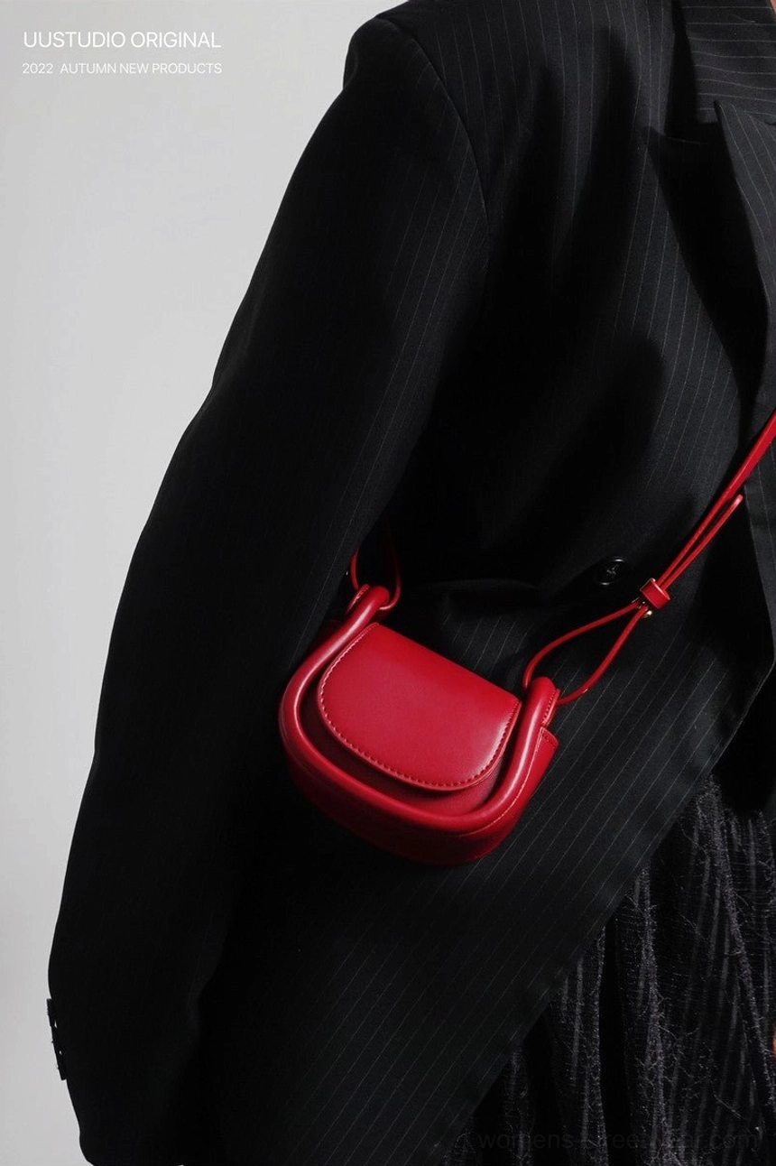 Scarlet red mini saddle crossbody bag with smooth finish styled with an all-black streetwear outfit