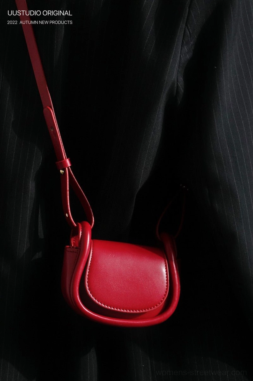 Front angled view of a scarlet red mini saddle crossbody bag with a clean flap design