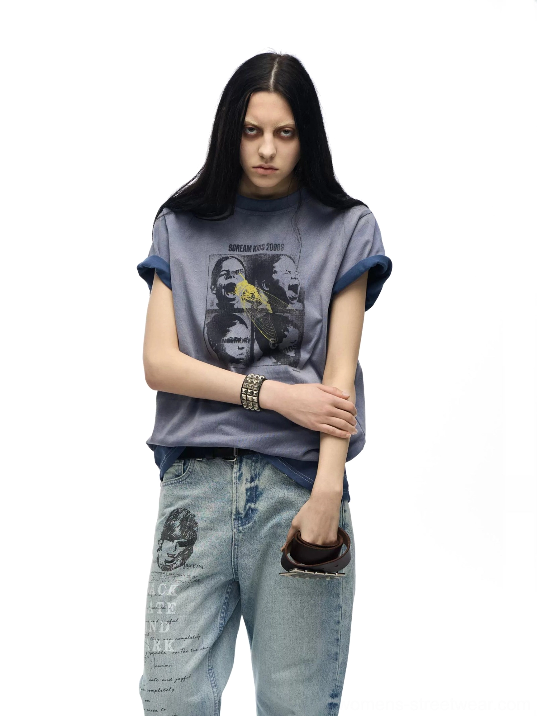 Female model wearing a dusty blue washed rolled-sleeve Scream Kids graphic tee with loose printed jeans on a white studio background