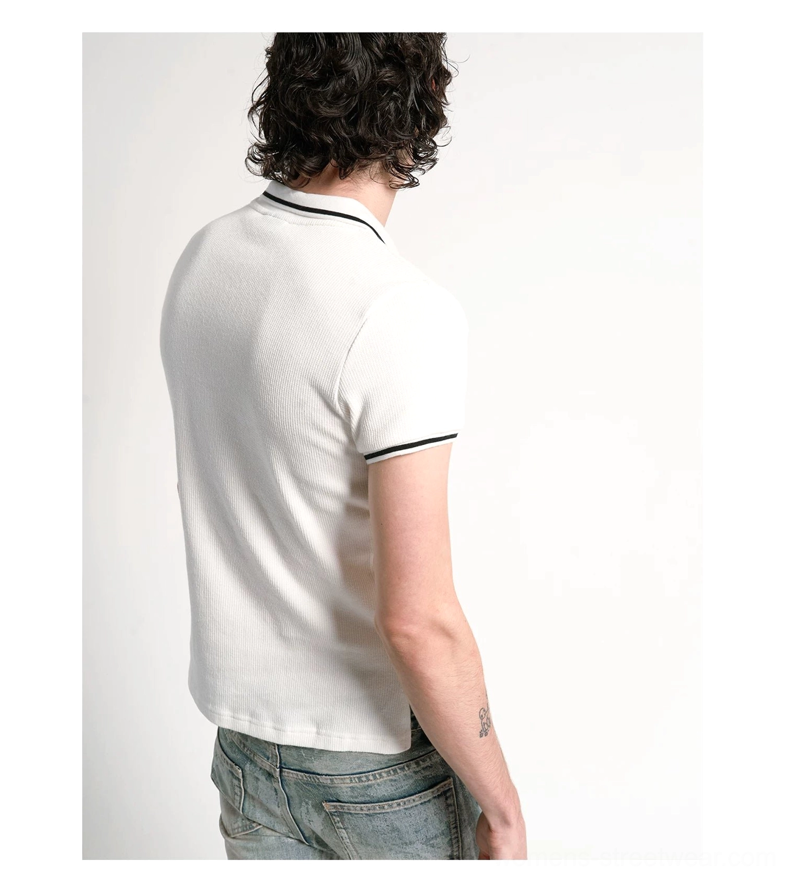 Back view of white cotton pique polo shirt showing black contrast sleeve cuffs and breathable textured fabric