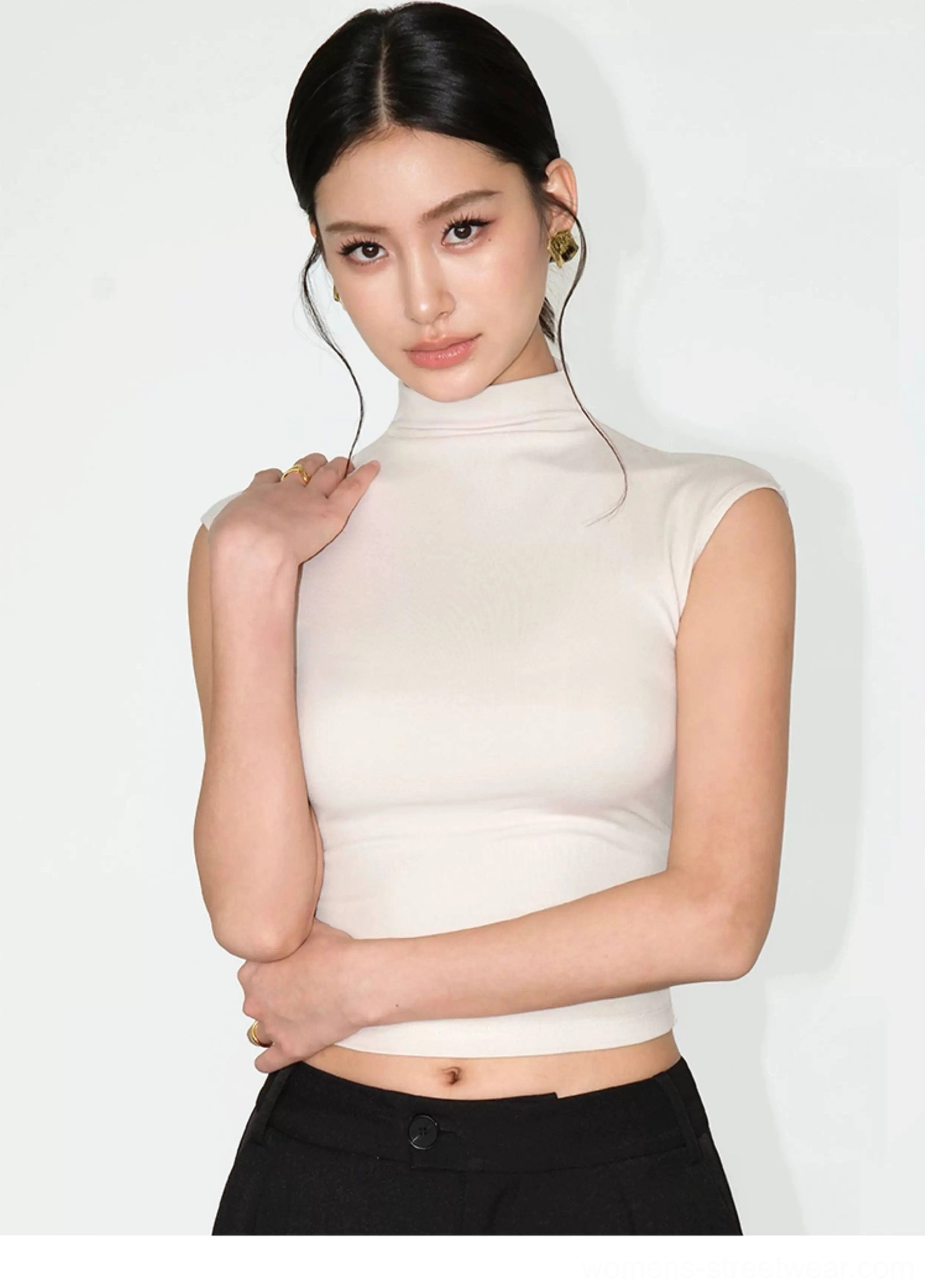 Off white fitted sleeveless mock neck knit top close view showing smooth stretch fabric and high neckline