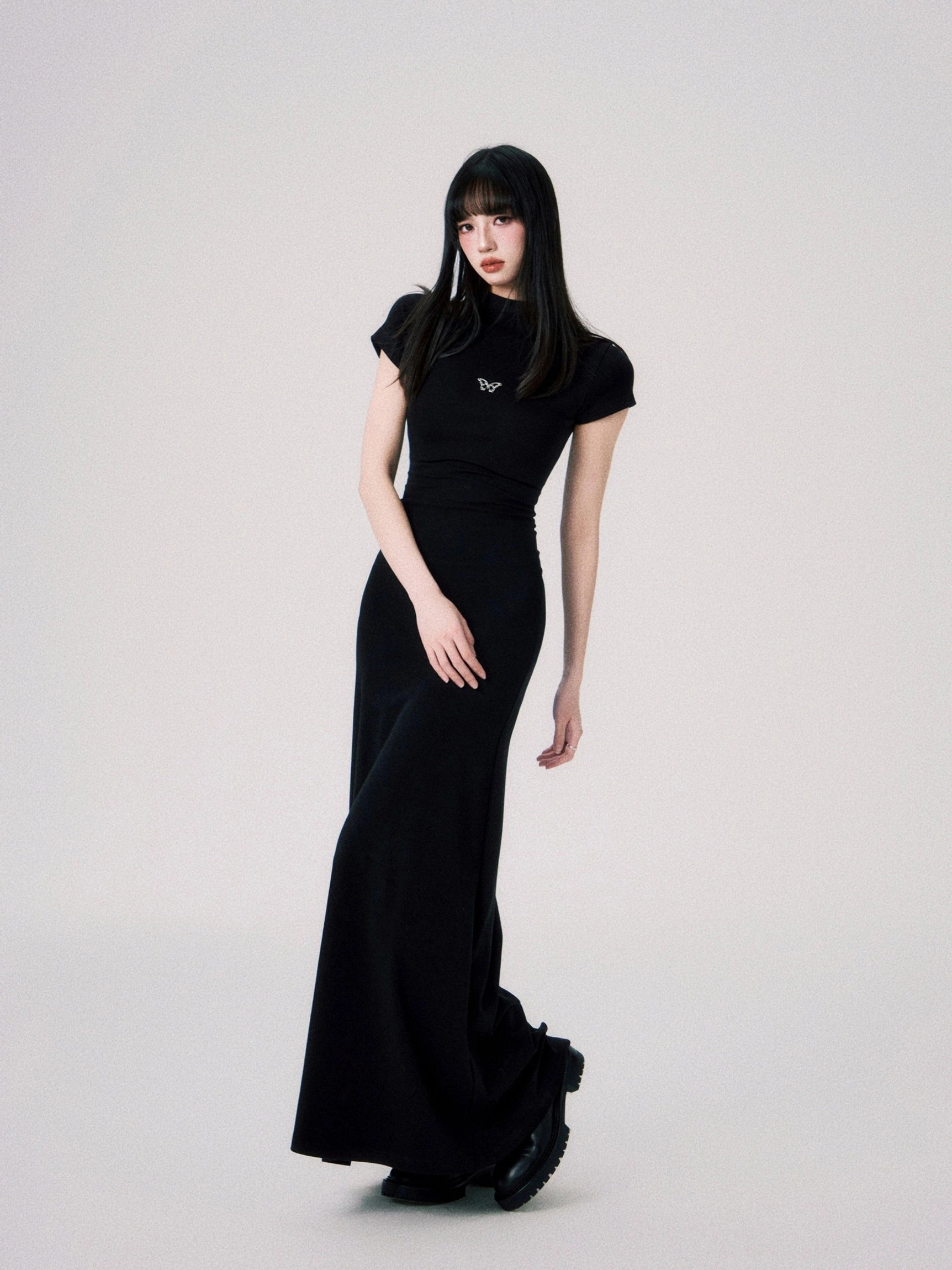 Seoul inspired fitted maxi dress with butterfly emblem sleek mock neck and body sculpting silhouette