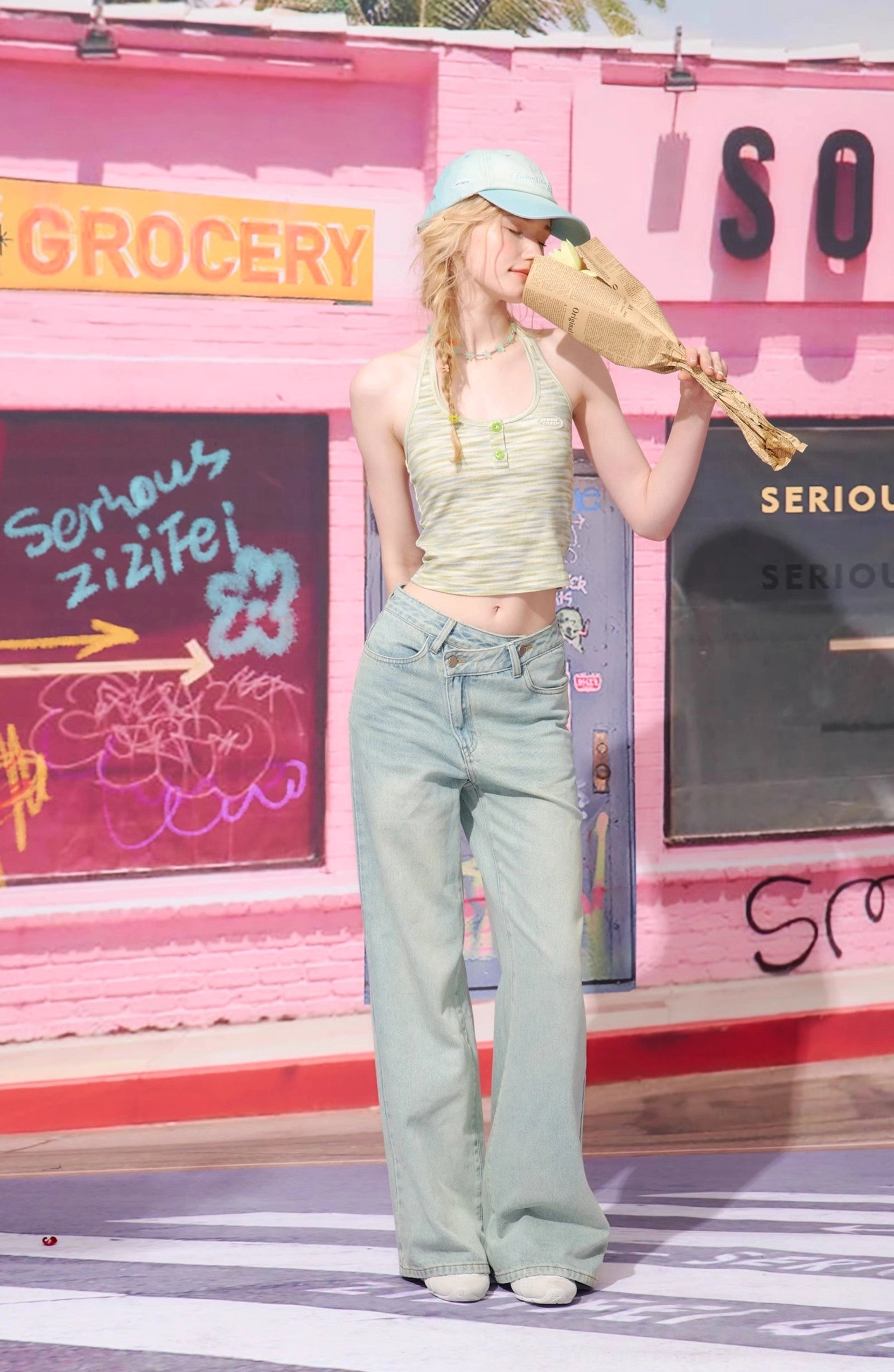 Casual Seoul-inspired streetwear look with light wash wide leg jeans, green halter top, cap, and grocery bag