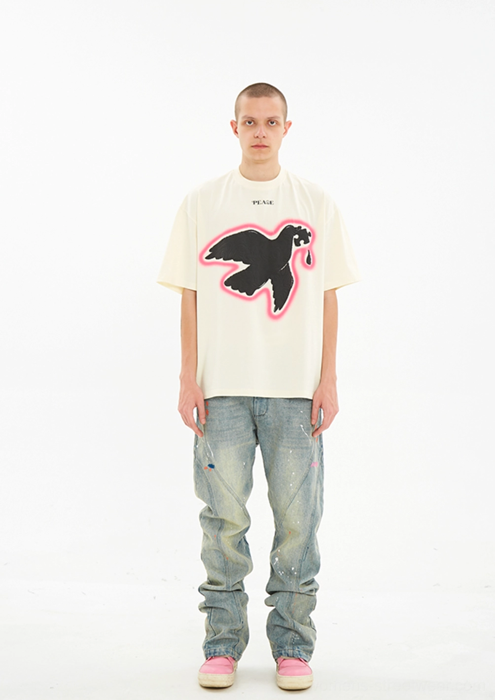 Full body front view of Serene Dove oversized suede foam print T-shirt styled with paint splatter blue jeans and pink sneakers