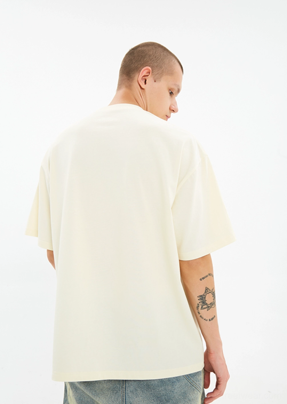 Back view of male model wearing the Serene Dove off white oversized streetwear T-shirt with clean unprinted back