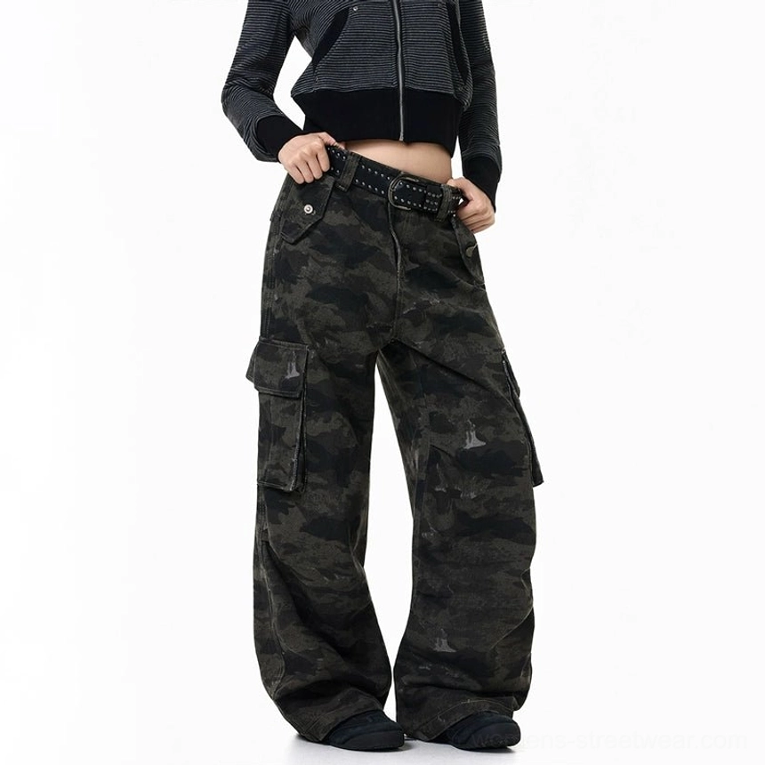 Close front right fit view of dark camouflage wide-leg cargo pants showing the right flap pocket, waistband, worn camo print, and baggy silhouette
