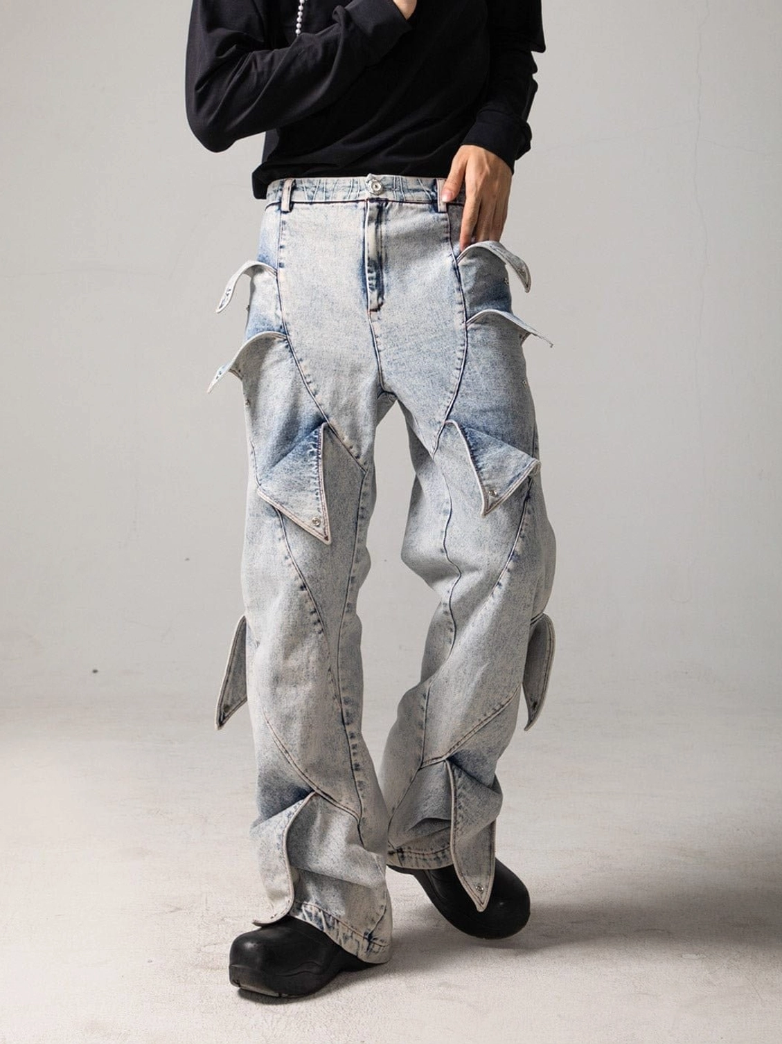 Front view of light blue acid wash shark fin panel baggy jeans with wide legs and sculpted streetwear denim details