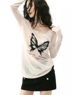 Side front view of a women's sheer apricot butterfly graphic long sleeve top with an oblique buttoned collar and Korean inspired streetwear styling