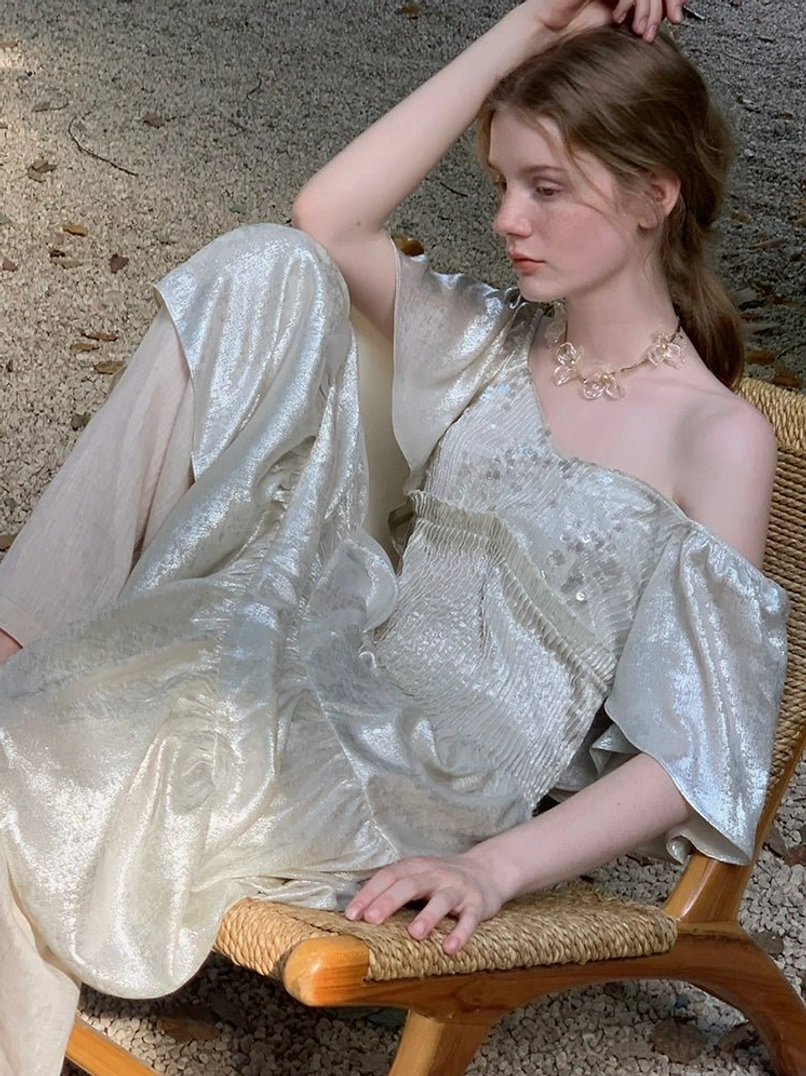 Asymmetrical one shoulder champagne shimmer tiered dress with ruffled sleeve and sequin bodice detail