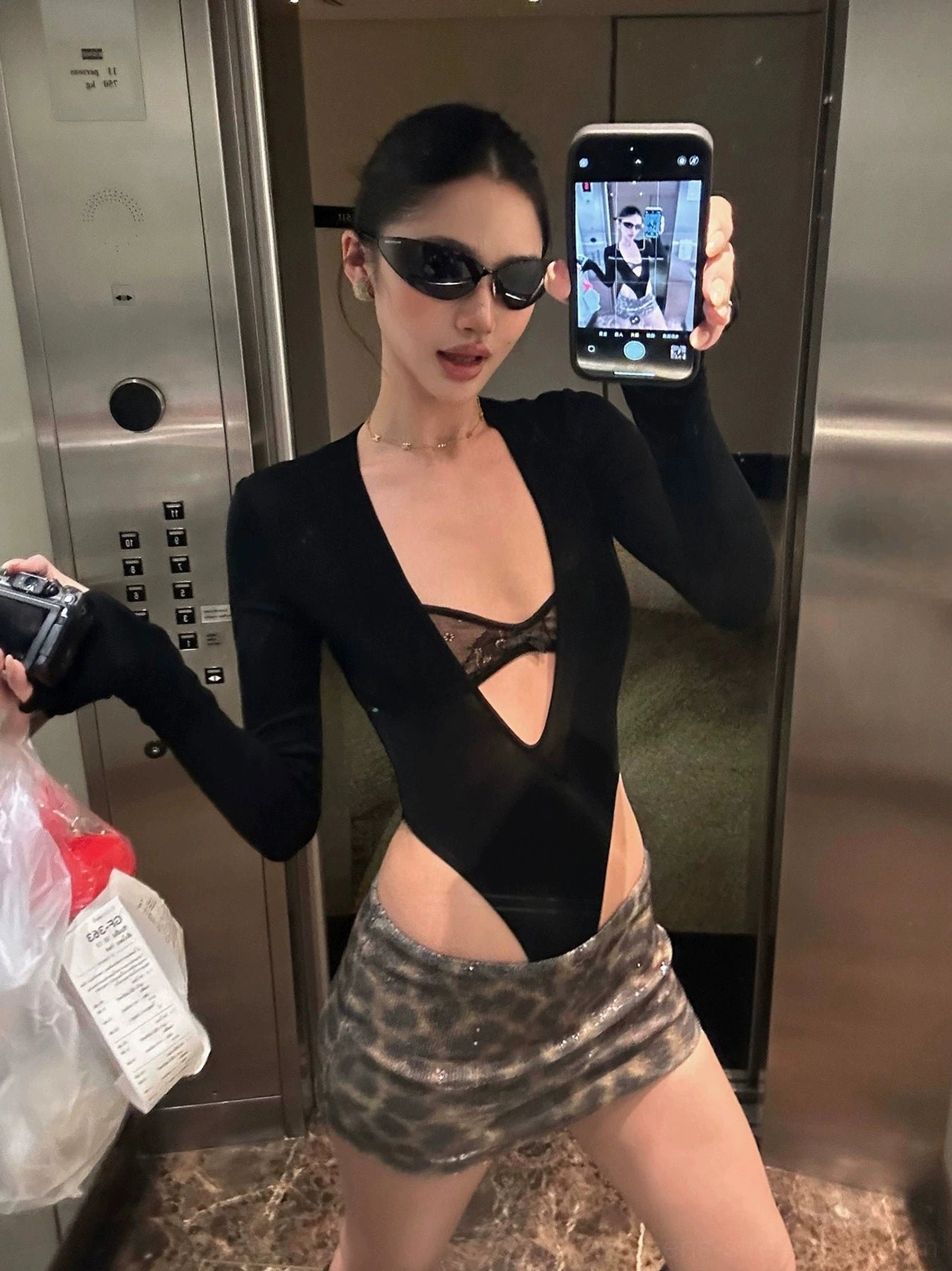 Close mirror selfie showing the shiny leopard sequin texture on a fitted brown mini skirt