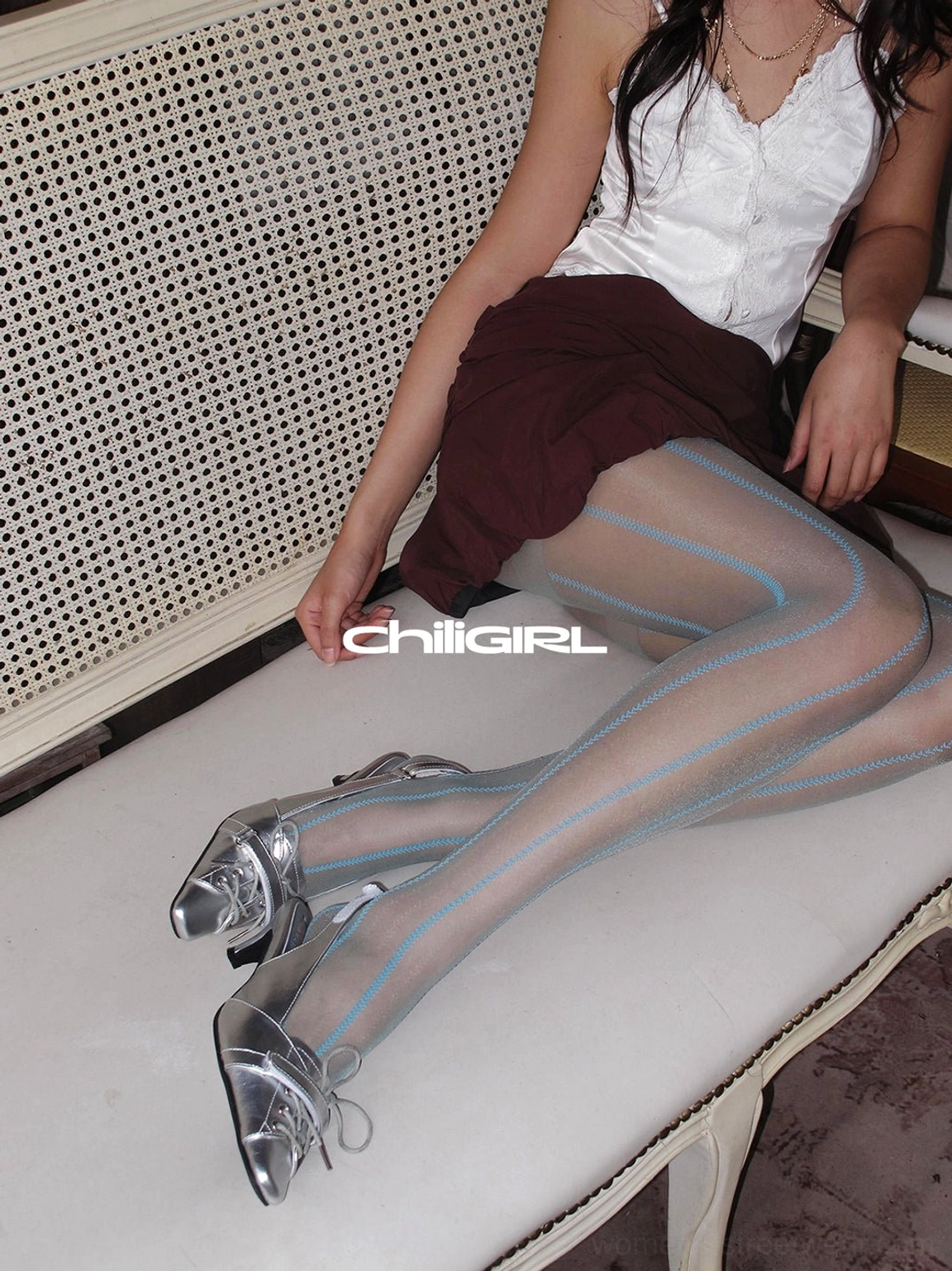 Model wearing shiny silver kitten heel slingback shoes with a white lace camisole and burgundy mini skirt
