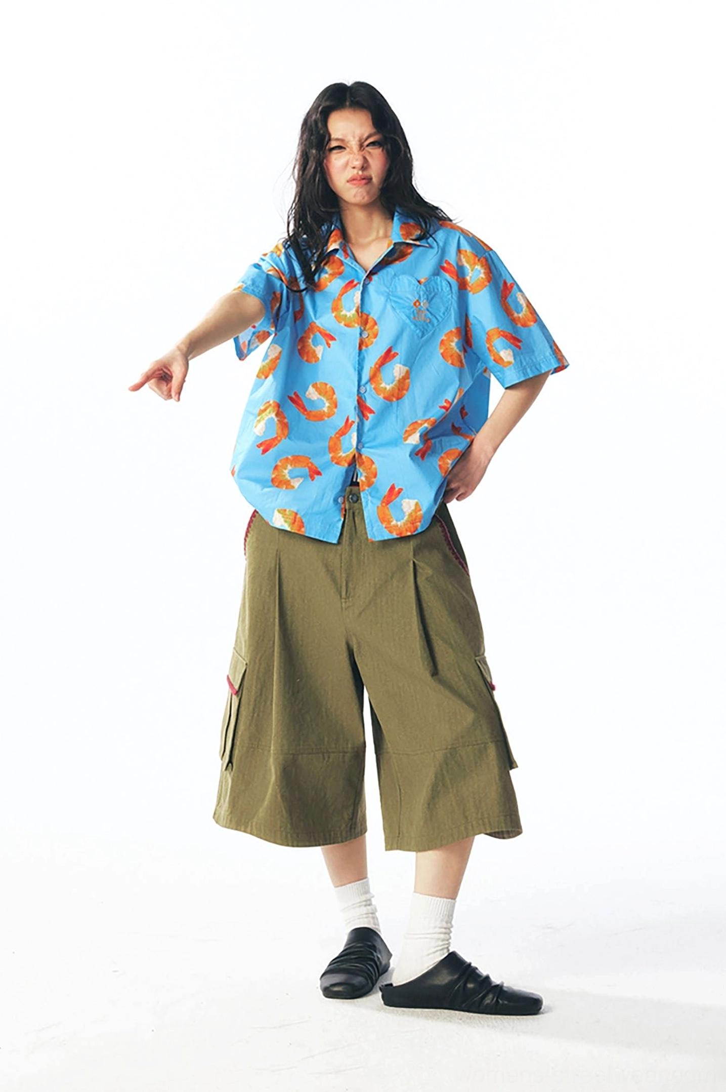 Female model wearing relaxed shrimp print casual button shirt with olive cropped cargo pants in a modern streetwear outfit