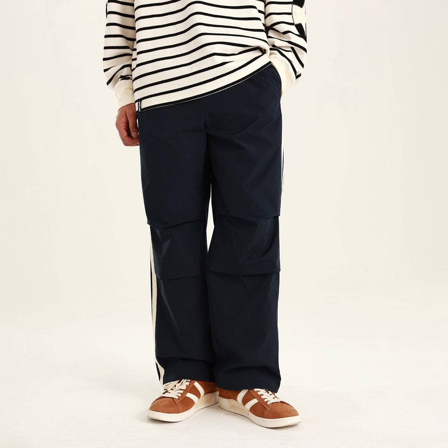Blue relaxed streetwear pants with straight-leg utility silhouette and structured knee pleat detailing