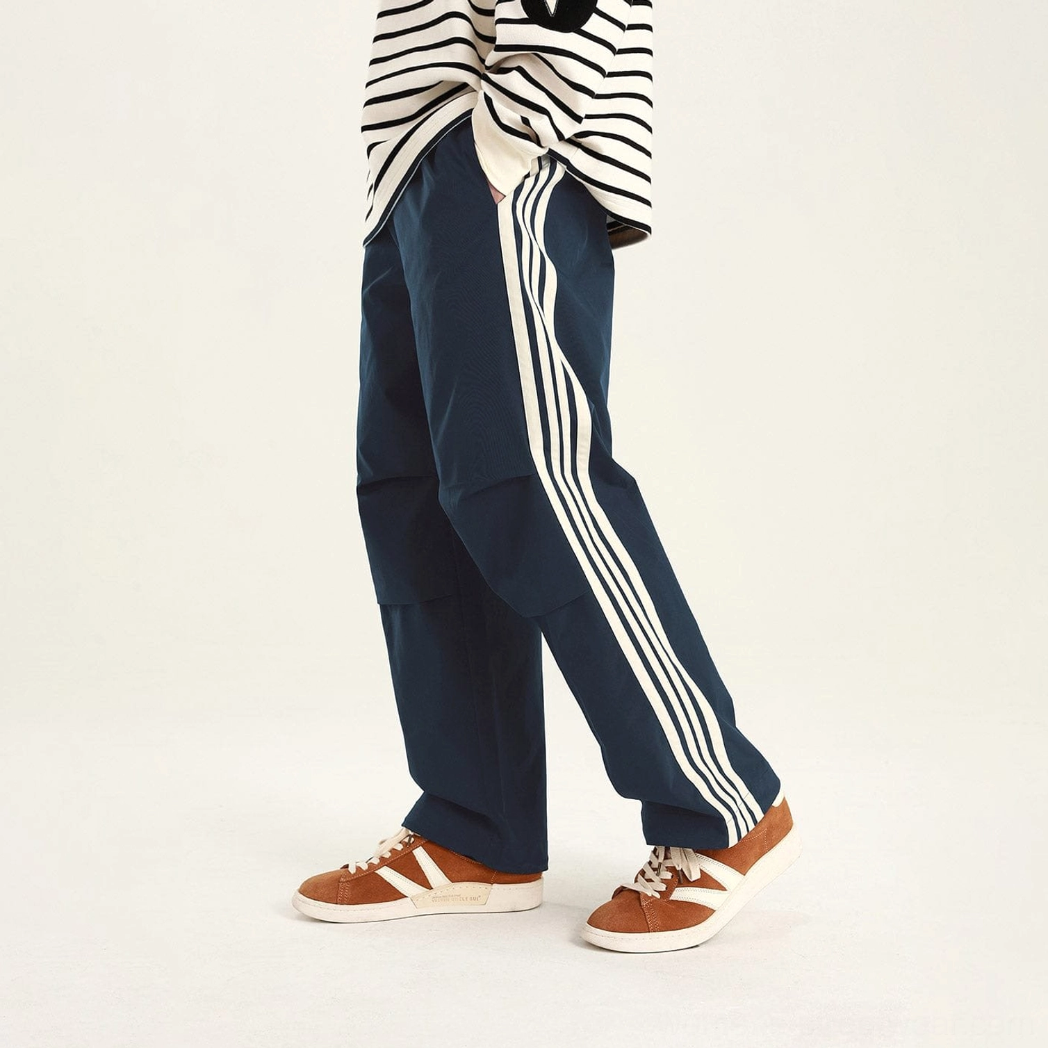 Blue side-stripe streetwear cargo pants with relaxed utility fit, contrasting white side stripes, and pleated knees