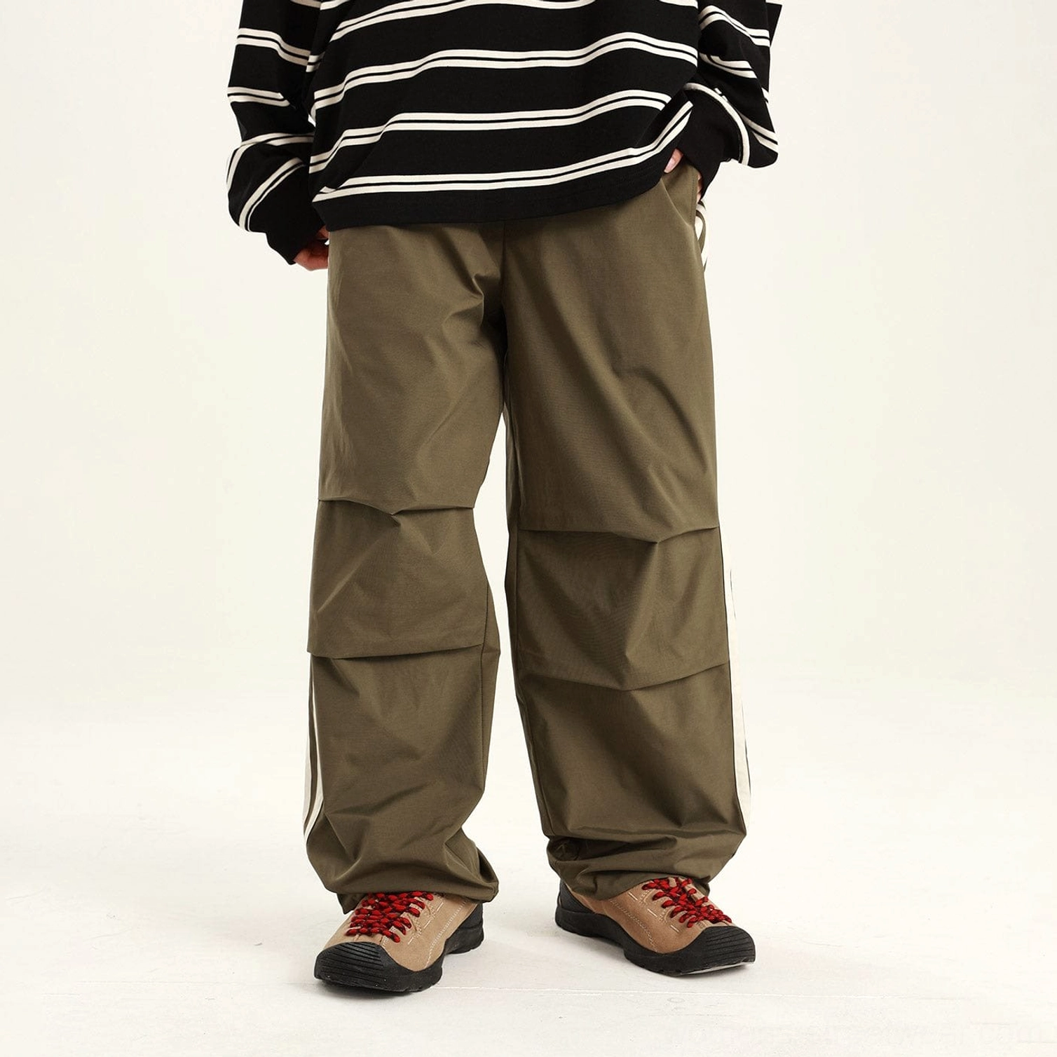 Green relaxed streetwear utility pants shown from the front with articulated knee pleats and straight-leg cut