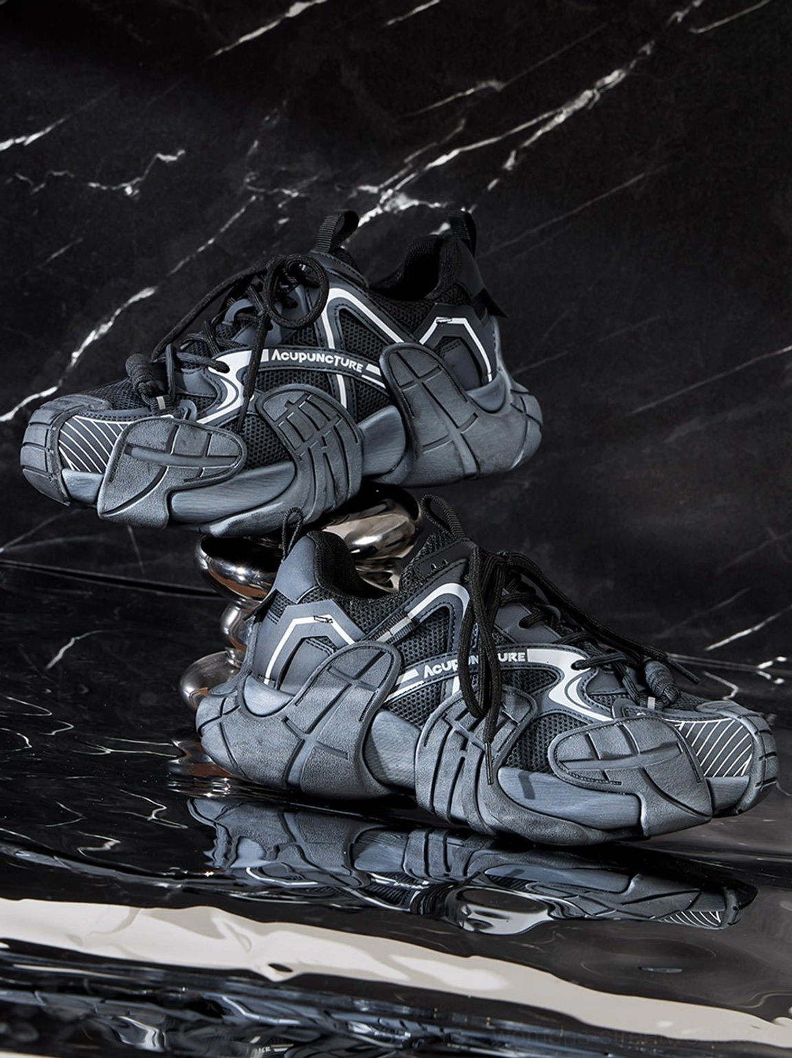 Silver cage panel chunky platform sneakers stacked on glossy black marble showing mesh upper