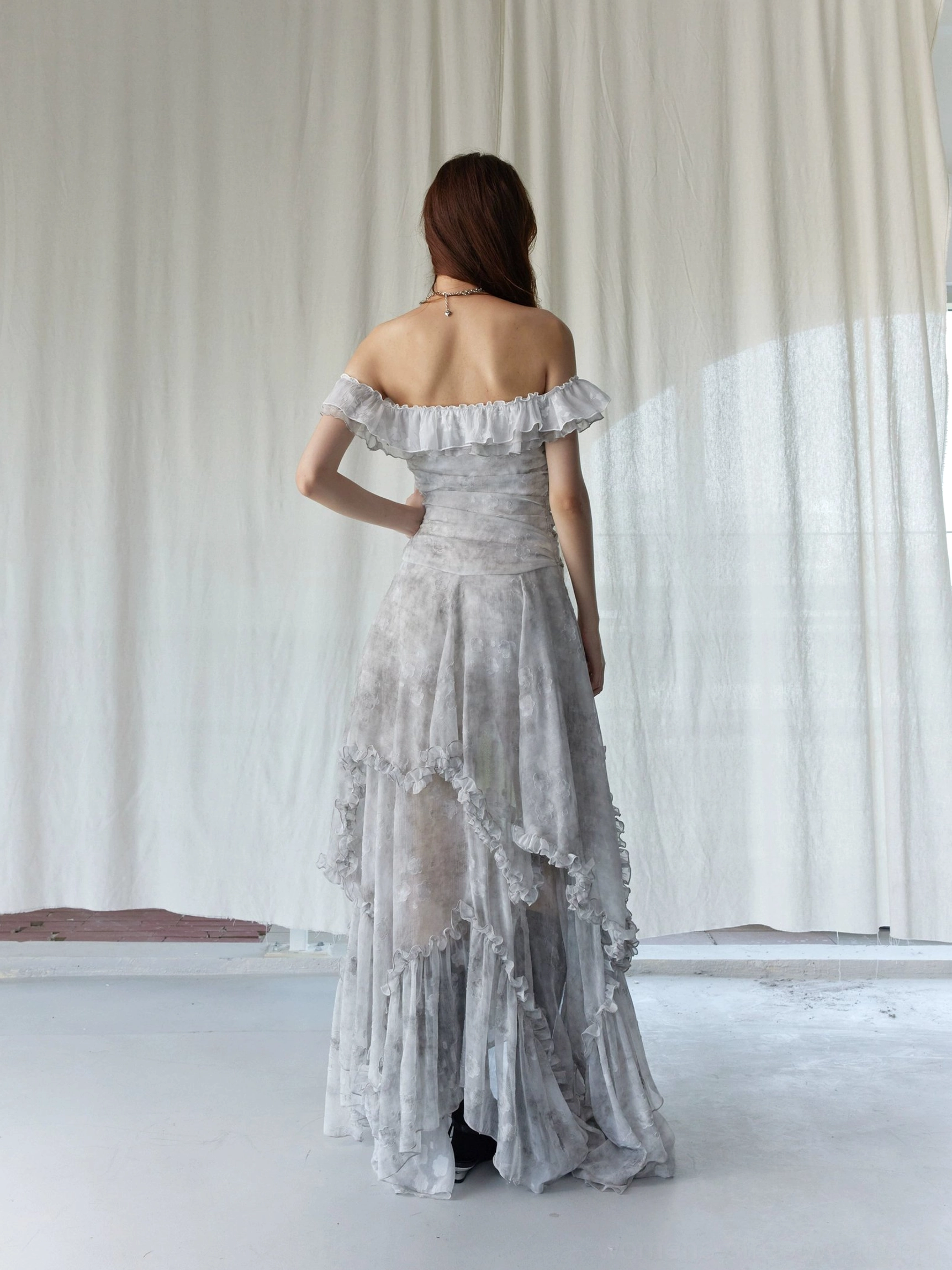 Back view of silver gray tie-dye off-shoulder ruffled maxi dress showing open-back detail and asymmetrical layered hem