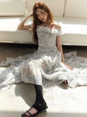 Silver gray tie-dye off-shoulder ruffled maxi dress with ruched bodice and layered floor-length sheer skirt styled in a seated fairycore fashion look
