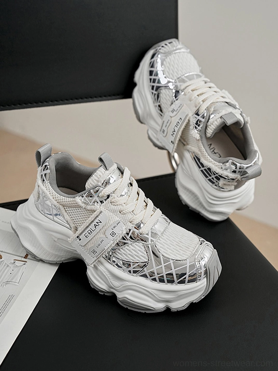 Silver mesh chunky tech runner sneaker viewed from the front side with padded heel counter, rear pull tab, adjustable strap, breathable upper, and thick white outsole
