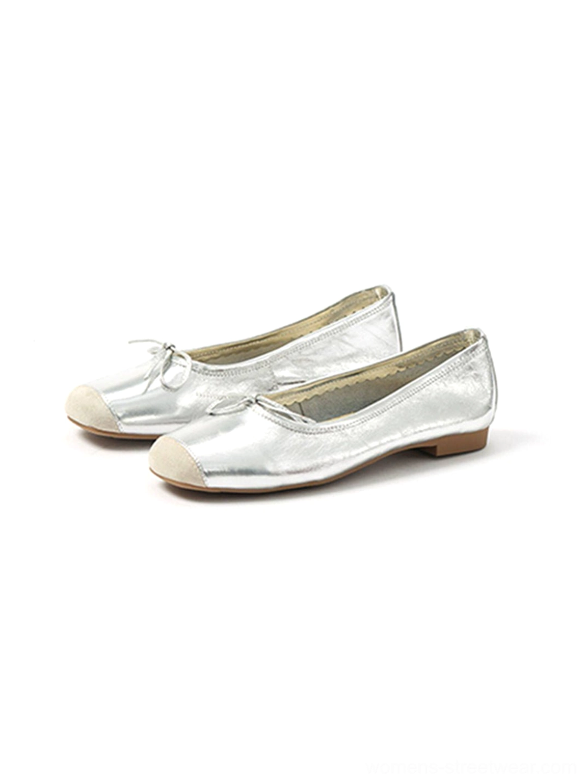 Oblique side view of silver metallic bow ballet flats with contrasting toe caps and low brown soles